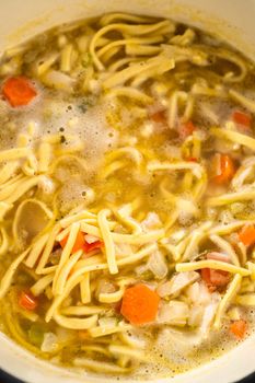 Cooking chicken noodle soup with kluski noodles in an enameled dutch oven.