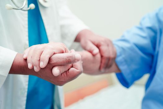 Doctor holding hands Asian elderly woman patient, help and care in hospital.