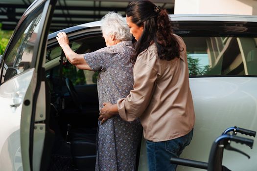 Caregiver help Asian elderly woman disability patient get in her car, medical concept.