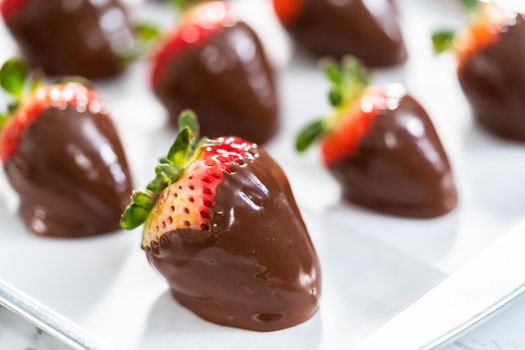 Making white and dark chocolate dipped strawberries.