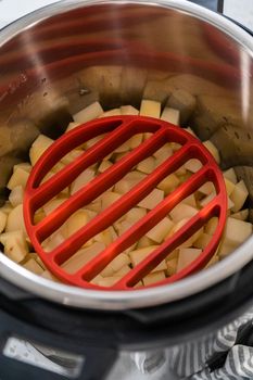 Cooking potatoes and eggs in a pressure cooker to make potato salad.