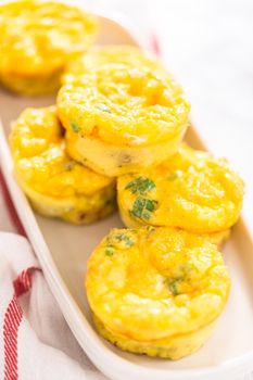 Bacon and cheese egg muffin on a white serving plate.
