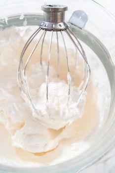 Mixing ingredients in kitchen electric mixer to bake meringue cookies.