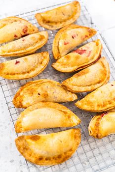 Freshly baked sweet cherry empanadas in the air fryer on the kitchen counter.