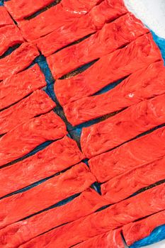 Rolling red and blue bread dough to bake patriotic cinnamon twists.