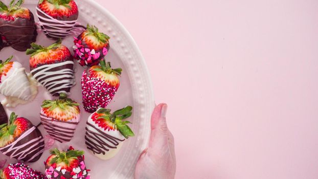 Flat lay. Step by step. Variety of chocolate dipped strawberries on a pink cake stand.