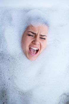 Closeup portrait of a girl in a bathtub and white foam around her face. Different emotions, grimaces, woman smile