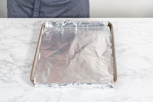 Scooping bread dough into paper liners to bake mini Easter bread kulich.