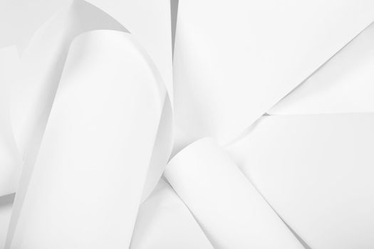 White sheets of office paper are twisted and scattered. Paper white abstract background.