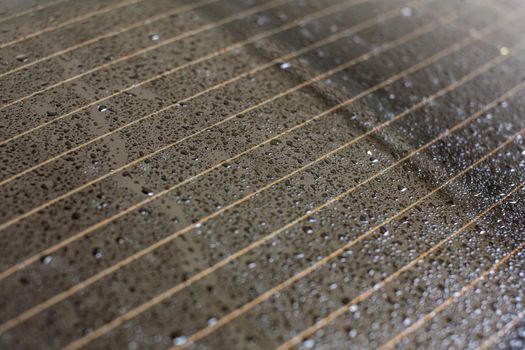 Drops of water on rear car window, orange heating stripes in glass.