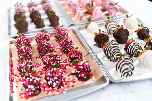 Variety of chocolate dipped strawberries on parchment paper.