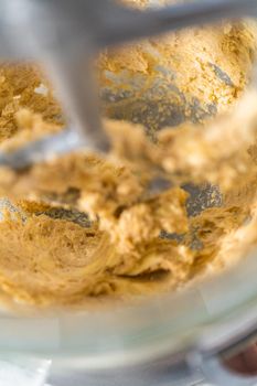Mixing ingredients in kitchen mixer to bake mini Easter bread kulich.