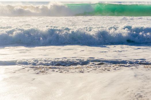 Ocean waves with white foam on a sunny day background