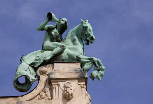 Women's equestrian statue with curtain, building decoration with blue sky background.Szechenyi Bath Budapest, Hungary.