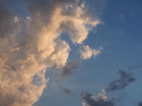 dramatic stormy blue sky with dark clouds at sunset useful as a background