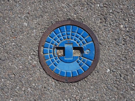 detail of a blue manhole in the street