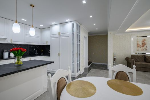 Remodel idea of rich white large modern domestic kitchen with black marble worktop and serverd dining table after renovation