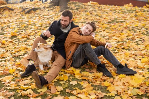 Father and son with a pet on a walk in the autumn park.