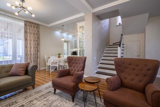 Luxury studio apartment, view from living room to white large kitchen and round dining table