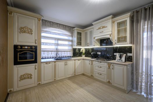 White rich classic cozy kitchen and dining room in city house interior