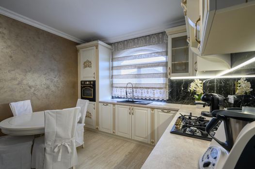 Modern classic white and beige luxurious kitchen with dining room in studio apartment interior