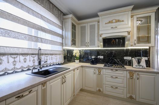 White rich classic cozy kitchen and dining room in city house interior