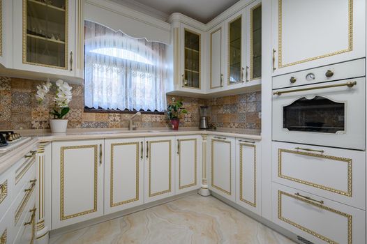 White classic cozy kitchen and dining room in city house interior