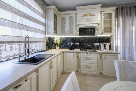 Modern classic white and beige luxurious kitchen with dining room in studio apartment interior