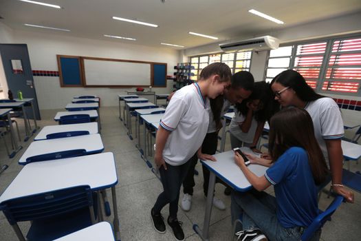 santana, bahia, brazil - september 13, 2022: students using smartphones in a classroom of a full-time state public school in the city of Santana.