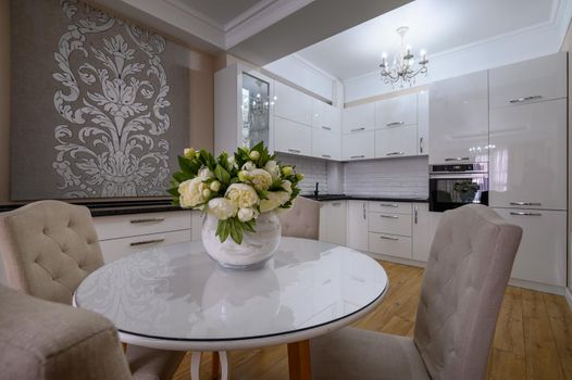 Luxury white modern kitchen with round dining table in studio apartment