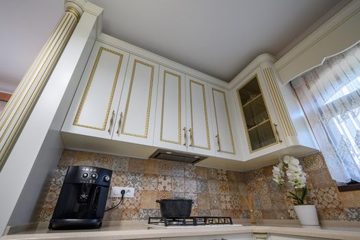 White classic cozy kitchen and dining room in city house interior