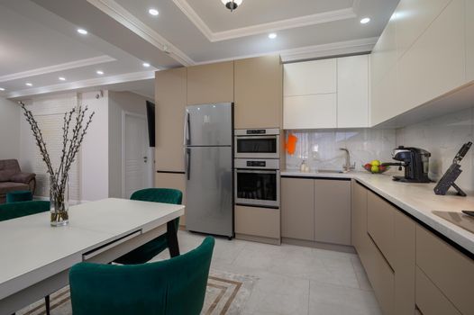 Modern classic white and beige luxurious kitchen with dining room in studio apartment interior