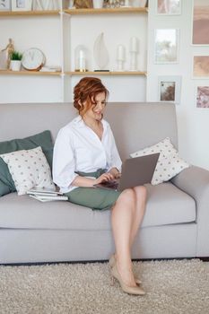 A business woman with a laptop. A human design specialist works at home on a laptop. Work from home during the epidemic.