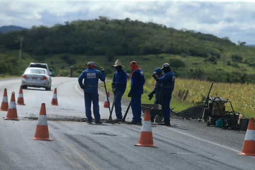 serra preta, bahia, brazil - september 13, 2022: workers recovering the BA 052 highway lane in the city of Serra Preta.
