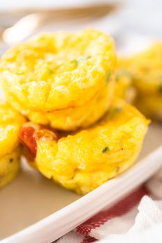 Bacon and cheese egg muffin on a white serving plate.