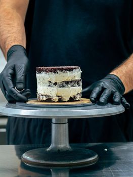 professional baker decorating a chocolate and cream cake with salty caramel