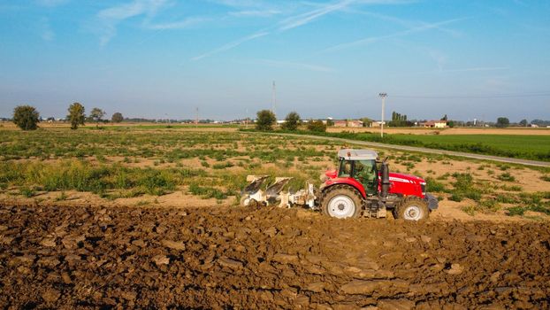 Aerial view with drone of tractor plowing the land in the countryside.
