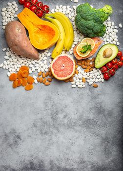 Vegetables, fruit and foods containing potassium, stone background, top view, space for text. Natural sources of potassium, vitamins and micronutrients, healthy balanced diet, avitaminosis prevention