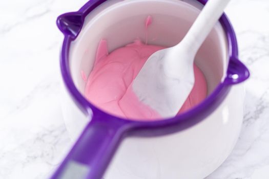 Melting chocolate melts in a candy melting pot to prepare hot chocolate bombs.