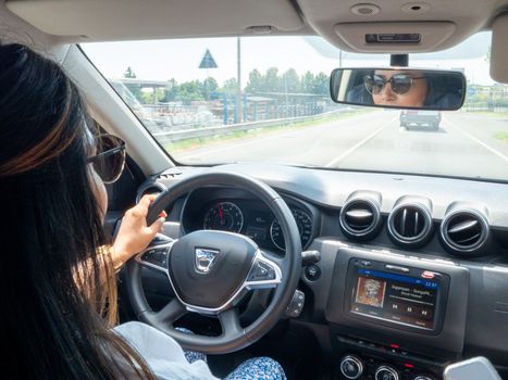 Beautiful business lady driving her car a cloudy day in summertime