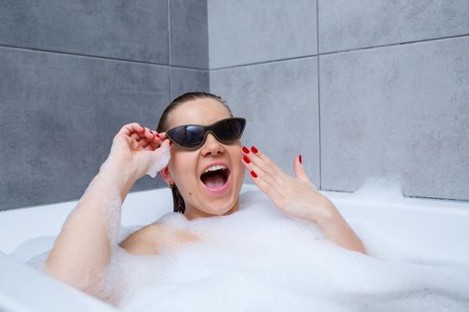 Young woman with sunglasses getting spa treatment in a beauty salon, inside an interior room. Relax in the bathroom without linen. Body care and relaxation concept.