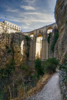 narrow path leading to the base of the new bridge of ronda on a cloudy day