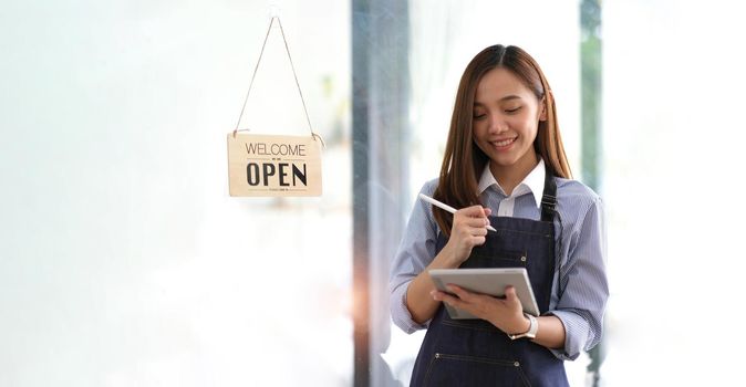 Startup successful small business owner sme beauty girl stand with tablet smartphone in coffee shop restaurant. Portrait of asian tan woman barista cafe owner. SME entrepreneur seller business concept.