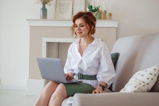 A business woman with a laptop. A human design specialist works at home on a laptop. Work from home during the epidemic.