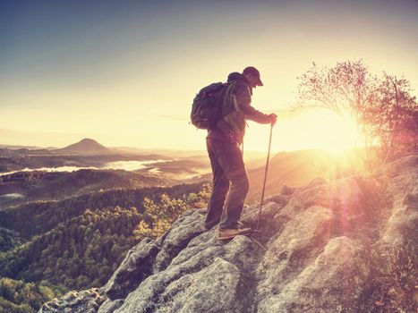 Climbing hiker with backpack in mountains. Rock climber in inspirational sunrise landscape in mountain range