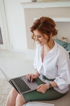 A business woman with a laptop. A human design specialist works at home on a laptop. Work from home during the epidemic.