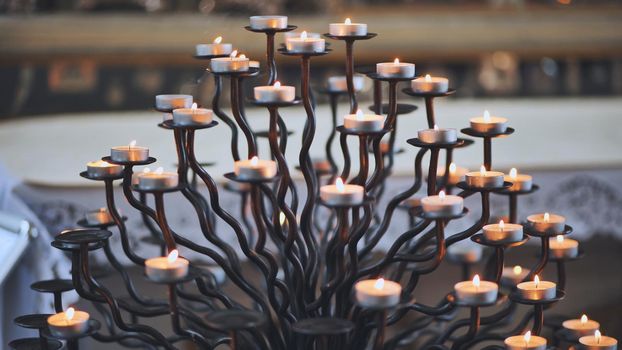 Candlestick holder with burning candles in a Catholic church