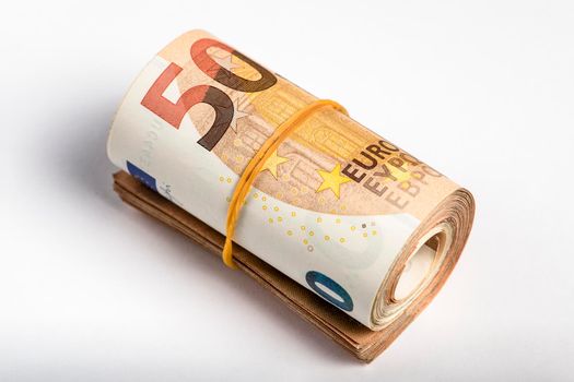 Roll of money. Roll of 50 euro banknotes. Euro banknotes rolled up on a gray background. The concept of financial assistance, real estate purchase, loan or insurance payment