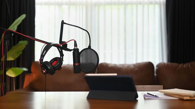 Home studio podcast with professional condenser microphone, tablet and headphone. Technology and audio equipment concept.