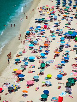 Italian beaches of Calabria seen from above, tourists seen rest under colorful umbrellas, travel reportage in Tropea Town
